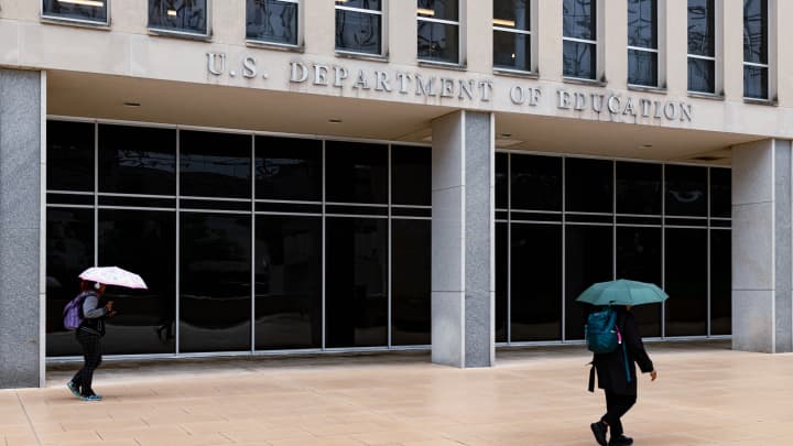 Trabalhadores deixam o prédio do Departamento de Educação durante uma chuva em Washington, D.C., na quarta-feira, 21 de maio de 2025. (Foto: Wesley Lapointe | The Washington Post | Getty Images)