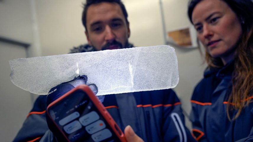 Cientistas belgas observam uma amostra de gelo azul em laboratório (Foto: NICOLAS TUCAT / AFP)