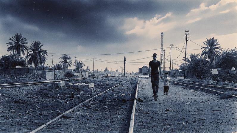 Uma família caminha ao longo de trilhos de trem destruídos na seção Mosul-Baghdad da linha no Iraque em 9 de julho. (Foto: Ben Buckland photos for Foreign Policy; maps adapted from a circa 1912 map titled "Proposed Berlin to Bagdad Railway")