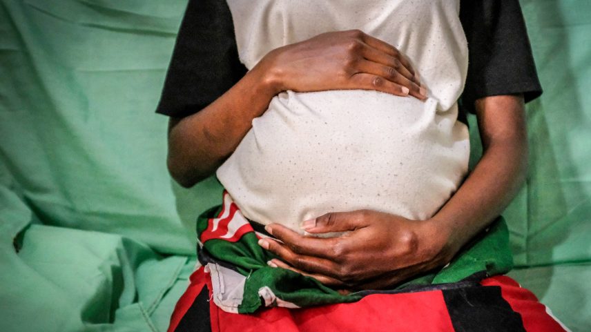 Uma mãe queniana de 19 anos é vista segurando sua barriga de 7 meses. (Foto: Reprodução)