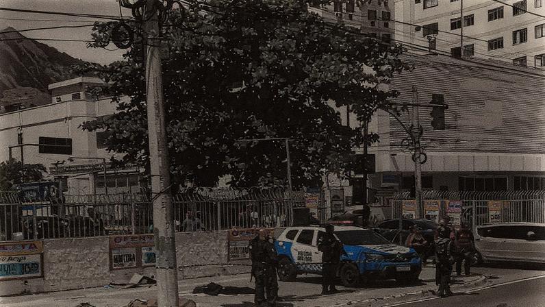 Viatura da PM ao lado de dois corpos na Rua Cândido Benício, na Praça Seca (Foto: Reprodução)