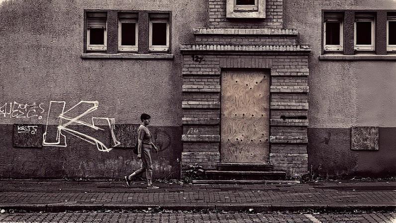 Uma mulher passa em frente a uma casa no bairro de Scholven, em Gelsenkirchen, onde o AfD obteve bons resultados (Foto: Reprodução)