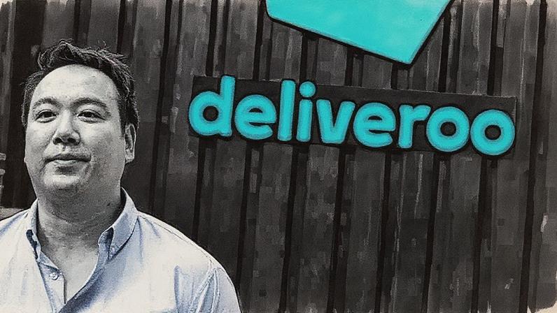 Homem de terno em pé, falando ao microfone, com um grande telão ao fundo exibindo um gráfico azul em ascensão (Foto: Reprodução)