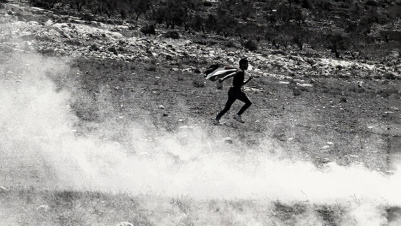 Pessoa segura bandeira palestina em Raba, na Cisjordânia ocupada por Israel (Foto: Reprodução)