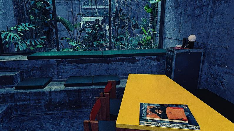 Cafeteria com mesas e bancos em salão de paredes de concreto e jardim nos fundos (Foto: Reprodução)