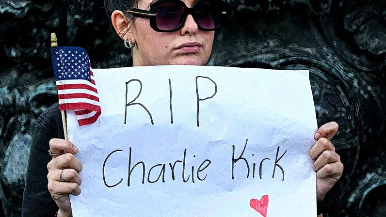 Contramanifestante segura um cartaz com os dizeres 'RIP Charlie Kirk' durante protesto contra a visita do presidente dos EUA, Donald Trump, perto do Castelo de Windsor (Foto: Reprodução)