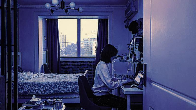 Mulher trabalha em um computador portátil em uma mesa de cozinha (Foto: Reprodução)