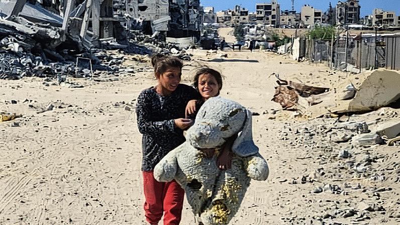 Two Palestinians walk through the destruction in Khan Younis, Gaza, on Tuesday. Photograph: Anadolu/Getty Images
