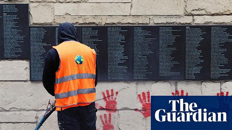 A city employee removing red handprint graffiti from the ‘wall of the righteous’ in Paris in May 2024.