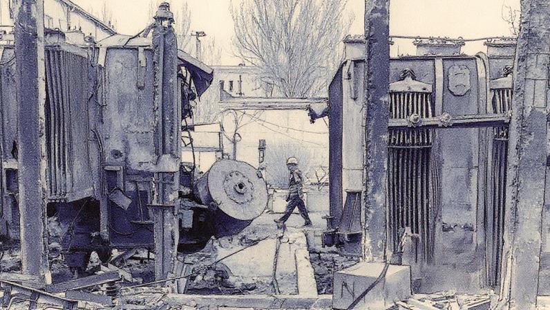 A worker walks past a Ukrainian substation destroyed by a Russian drone strike.