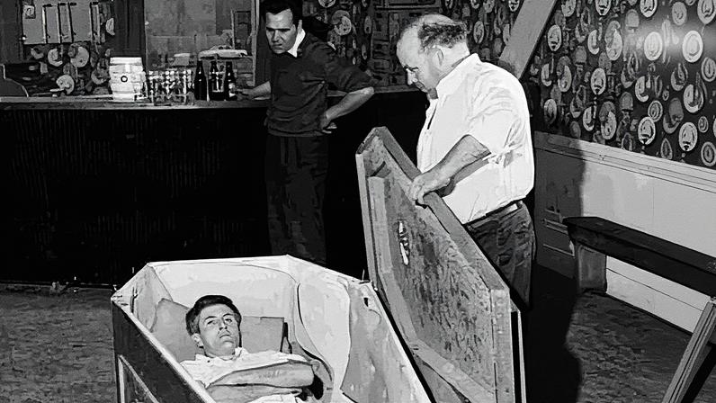Mike Meaney, in coffin, teamed up with Michael ‘Butty’ Sugrue, a circus performer turned publican and impresario, who staged a ‘wake’ in his pub. Photograph: TG4
